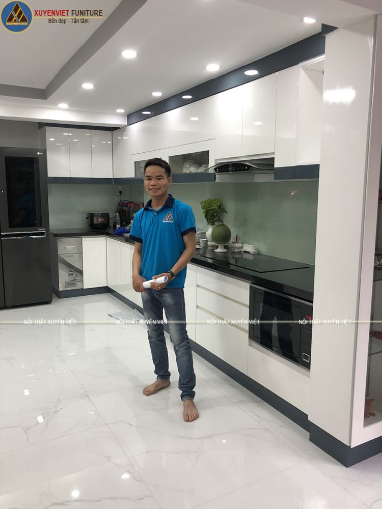 Nhân viên Xuyên Việt bên bộ tủ bếp đẹp vừa hoàn thiện Tủ bếp đẹp phủ sơn men bóng nhà anh Thể - quận 8